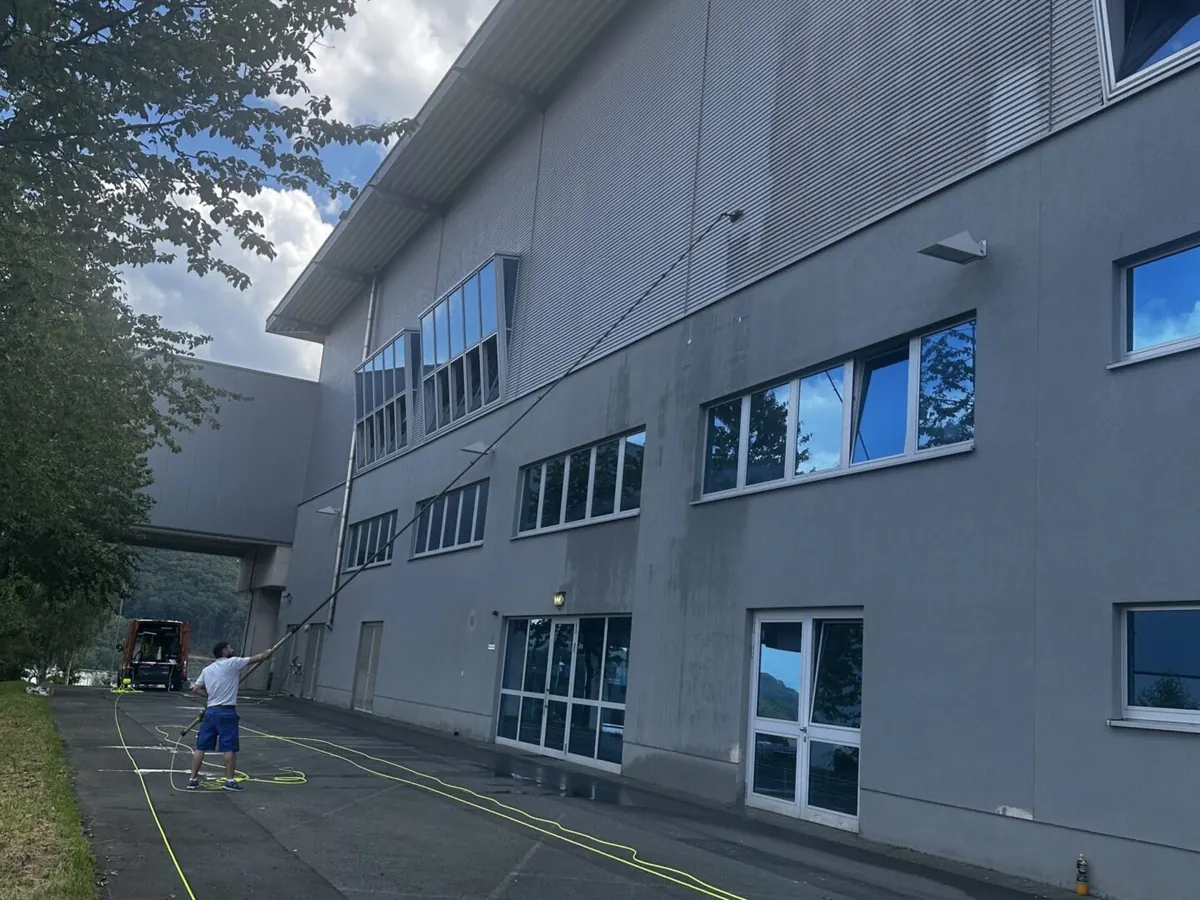 Lange Metallfassade eines Firmengebäudes während der Reinigung