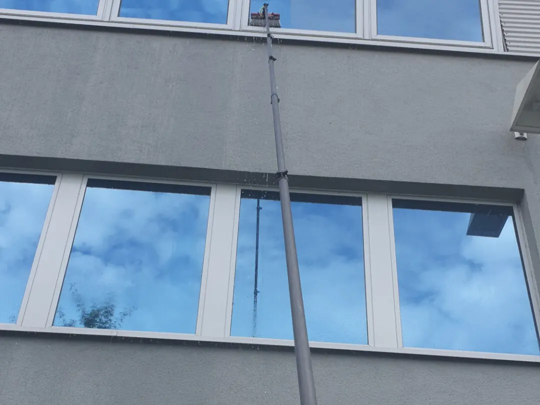 Carbonstange mit Bürste an einer mehrgeschossigen Fensterfront